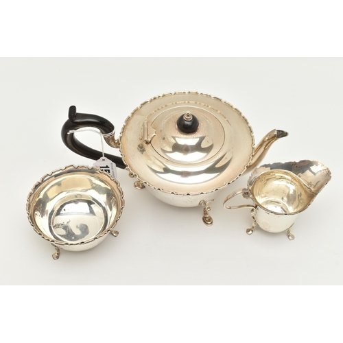 150 - AN EARLY 20TH CENTURY SILVER THREE PIECE TEA SET, comprising of a polished form with wavy rim teapot... 