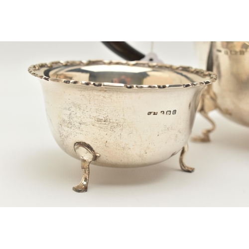 150 - AN EARLY 20TH CENTURY SILVER THREE PIECE TEA SET, comprising of a polished form with wavy rim teapot... 