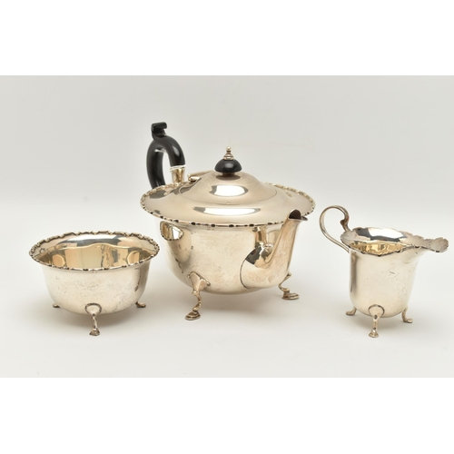 150 - AN EARLY 20TH CENTURY SILVER THREE PIECE TEA SET, comprising of a polished form with wavy rim teapot... 