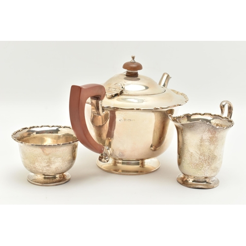 151 - A GEORGE VI SILVER THREE PIECE TEA SET, comprising of a polished form with wavy rim teapot, hinged c... 