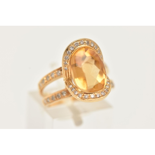 176 - A MODERN YELLOW METAL CITRINE AND DIAMOND DRESS RING, set with an oval shape fancy cut Citrine, meas... 