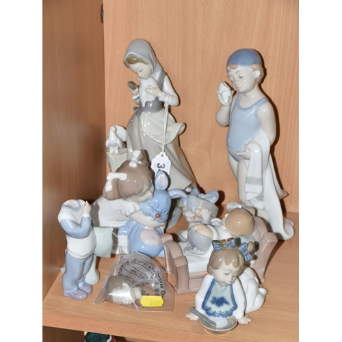 345 - A LLADRO FIGURE AND A GROUP OF NAO FIGURES, comprising Lladro Girl with Doves/ Pigeons, no 4915, scu... 