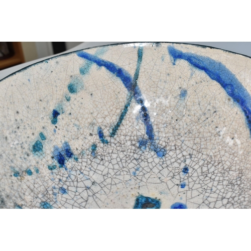 364 - CATRIONA McLEOD: A LARGE RAKU FIRED BOWL, decorated with blue and turquoise bands on a cream crackle... 