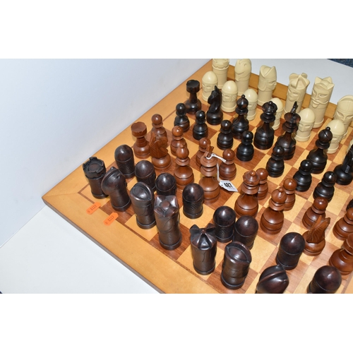 487 - A CHESSBOARD WITH TWO SETS OF CHESS PIECES, to include a Anne Carlton chess set, masked medieval fig... 