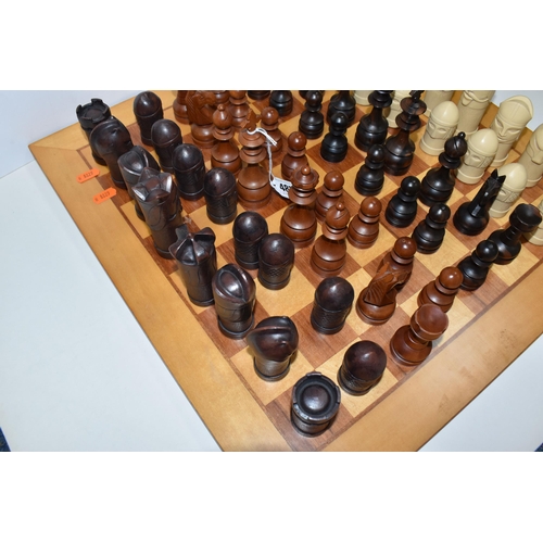 487 - A CHESSBOARD WITH TWO SETS OF CHESS PIECES, to include a Anne Carlton chess set, masked medieval fig... 