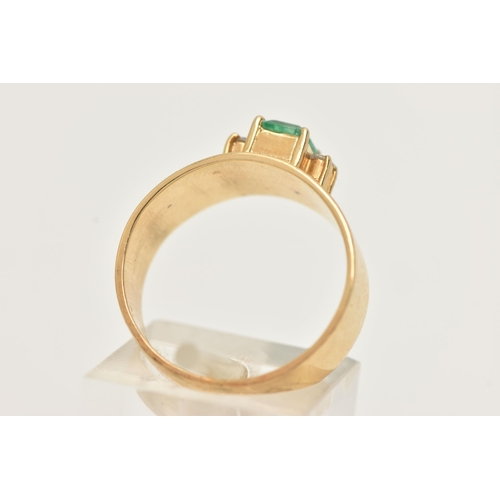 42 - A YELLOW METAL EMERALD AND DIAMOND RING, set with a raised emerald cut emerald, measuring approximat... 