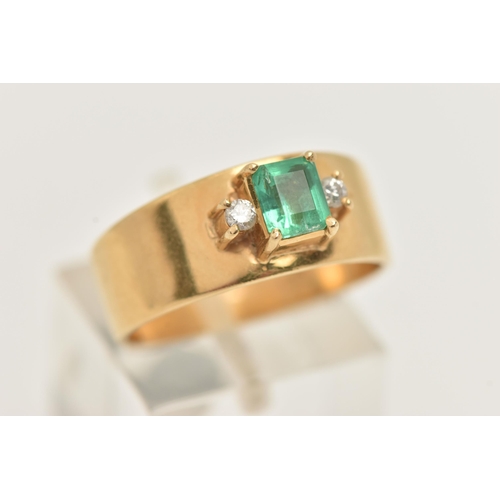 42 - A YELLOW METAL EMERALD AND DIAMOND RING, set with a raised emerald cut emerald, measuring approximat... 