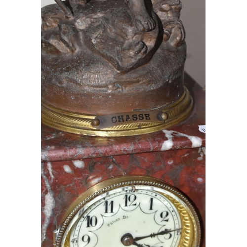 322 - A ROUGE MARBLE  MANTEL CLOCK,  a French clock surmounted by a spelter figure of a woman with a wild ... 