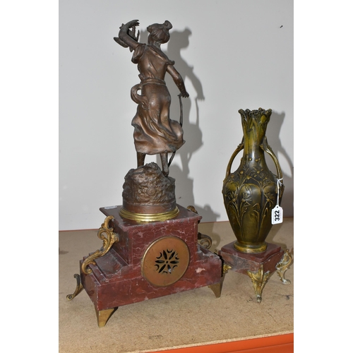 322 - A ROUGE MARBLE  MANTEL CLOCK,  a French clock surmounted by a spelter figure of a woman with a wild ... 