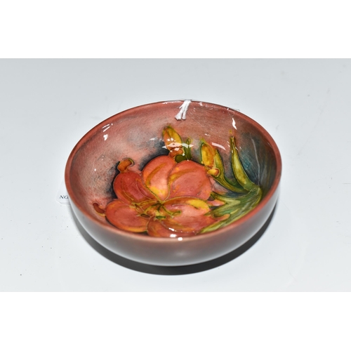 425 - A MOORCROFT POTTERY 'FREESIA' PATTERN FOOTED BOWL, diameter 8cm, a coral and yellow freesia on a mot... 