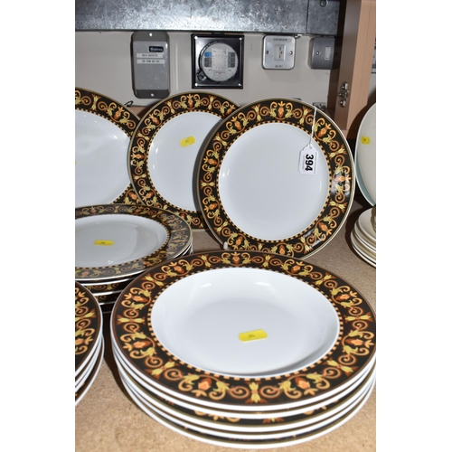 394 - A COLLECTION OF VERSACE DINNERWARE 'BAROCCO', a design of a black back ground rim, with shades of ye... 