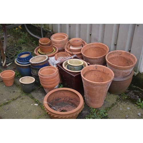 1002 - A LARGE SELECTION OF GLAZED AND TERRACOTTA PLANT POTS, of various sizes and shapes, along with a pai... 