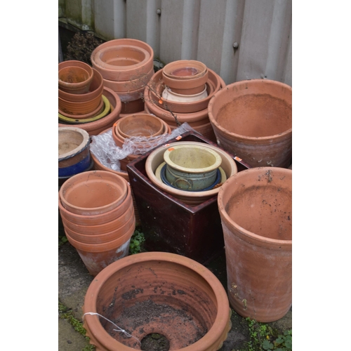 1002 - A LARGE SELECTION OF GLAZED AND TERRACOTTA PLANT POTS, of various sizes and shapes, along with a pai... 