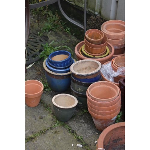 1002 - A LARGE SELECTION OF GLAZED AND TERRACOTTA PLANT POTS, of various sizes and shapes, along with a pai... 