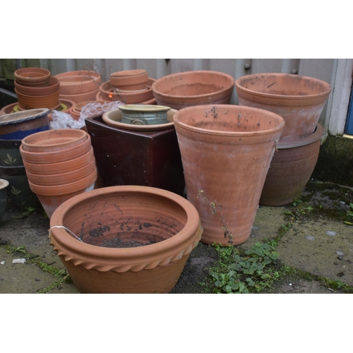 1002 - A LARGE SELECTION OF GLAZED AND TERRACOTTA PLANT POTS, of various sizes and shapes, along with a pai... 