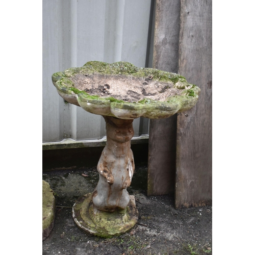 1012 - A WEATHERED COMPOSITE SHELL SHAPED BIRD BATH, on a later base depicting a standing otter, height 64c... 