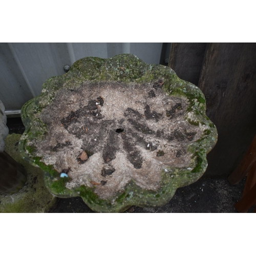 1012 - A WEATHERED COMPOSITE SHELL SHAPED BIRD BATH, on a later base depicting a standing otter, height 64c... 