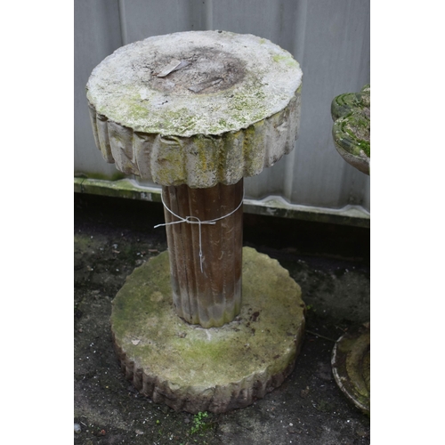 1012 - A WEATHERED COMPOSITE SHELL SHAPED BIRD BATH, on a later base depicting a standing otter, height 64c... 