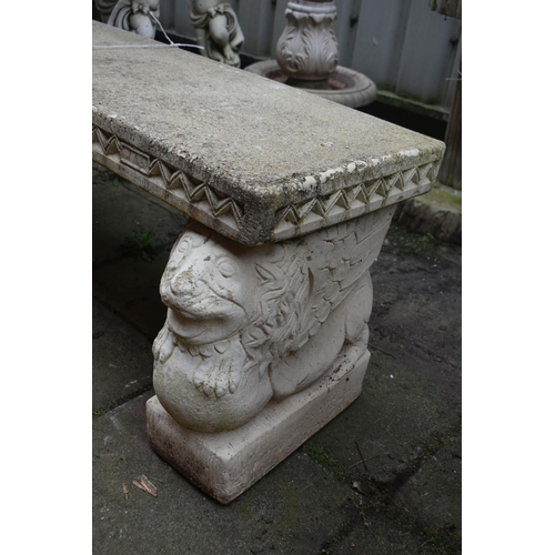 1013 - A WEATHERED PAINTED COMPOSITE GARDEN BENCH, on a pair of stands depicting lions on a ball, length 12... 