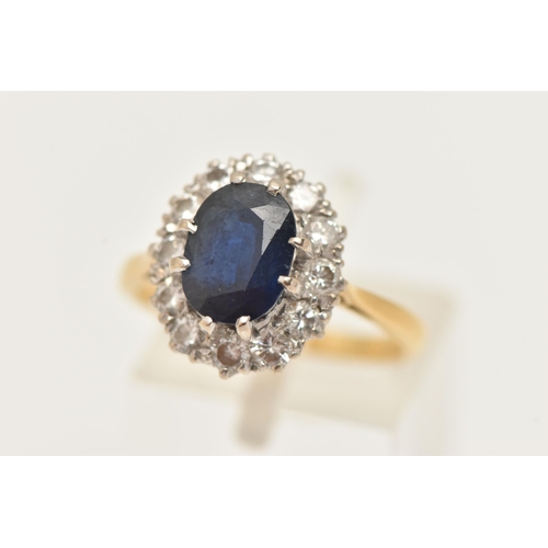 21 - A YELLOW METAL SAPPHIRE AND DIAMOND CLUSTER RING, set with a central oval cut deep blue sapphire, do... 