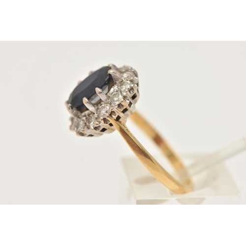 21 - A YELLOW METAL SAPPHIRE AND DIAMOND CLUSTER RING, set with a central oval cut deep blue sapphire, do... 