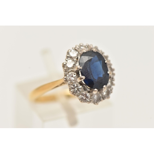 21 - A YELLOW METAL SAPPHIRE AND DIAMOND CLUSTER RING, set with a central oval cut deep blue sapphire, do... 