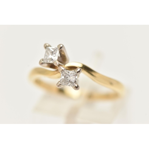 22 - AN 18CT GOLD DIAMOND CROSS OVER RING, designed as two princess cut diamonds each in a four claw sett... 