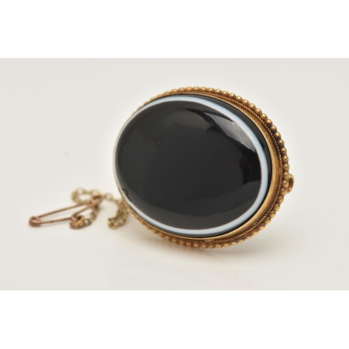 38 - A VICTORIAN BULLS EYE AGATE BROOCH, of an oval form, set with a bulls eye agate cabochon collet set ... 