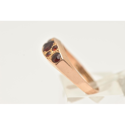 51 - A LATE VICTORIAN 15CT GOLD GARNET RING, set with seven circular cut garnets, to a polished band, hal... 