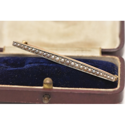 56 - AN EARLY 20TH CENTURY YELLOW METAL SPLIT PEARL BAR BROOCH, set with a row of graduating split pearls... 