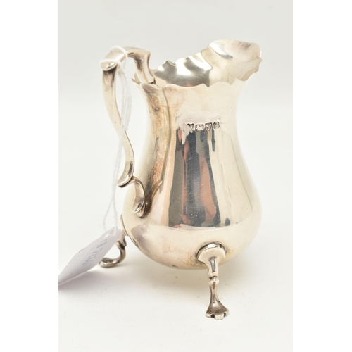 123 - AN EARLY 20TH CENTURY SILVER MILK JUG, polished form with wavy rim, fitted with a scrolling handle a... 