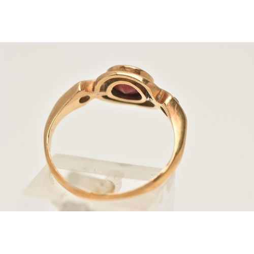 77 - A 22CT GOLD GEM SET RING, set with a central circular cut red stone assessed as garnet, collet set w... 