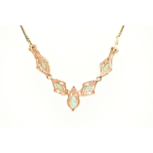 183 - A YELLOW METAL GEM SET NECKLACE, a V shape necklace comprised of five marquise cut emeralds and nine... 