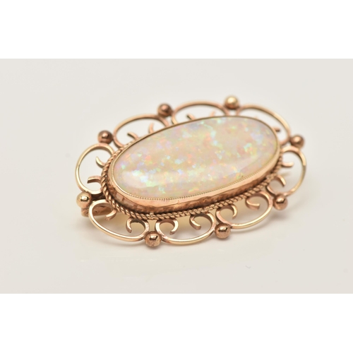 185 - A 9CT GOLD AND SYNTHETIC OPAL BROOCH, an oval synthetic opal, collet set with open work scrolling de... 