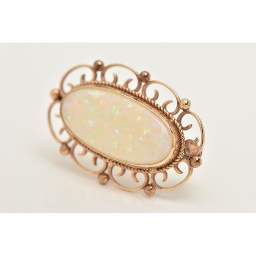 185 - A 9CT GOLD AND SYNTHETIC OPAL BROOCH, an oval synthetic opal, collet set with open work scrolling de... 