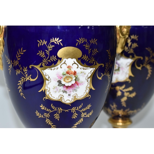 362 - A PAIR OF COALPORT COVERED VASES, of urn form with twin gilt ram's head handles, on a square pedesta... 