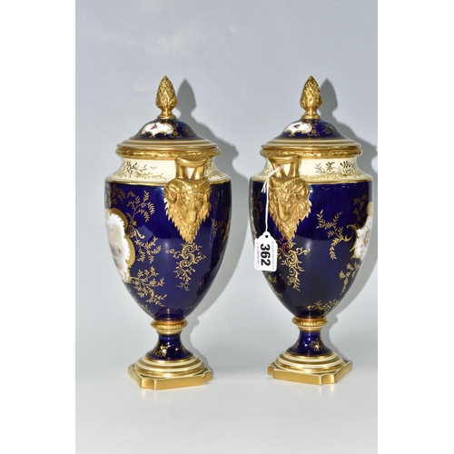 362 - A PAIR OF COALPORT COVERED VASES, of urn form with twin gilt ram's head handles, on a square pedesta... 