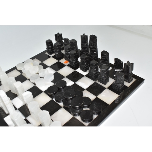 503 - A BLACK AND WHITE ONYX 'ABSTRACT AZTEC' CHESS SET with thirty-two chess pieces on a matching board, ... 