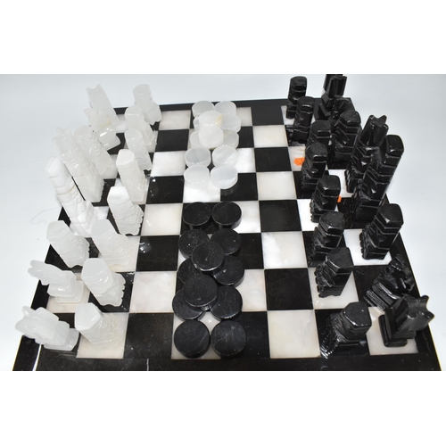 503 - A BLACK AND WHITE ONYX 'ABSTRACT AZTEC' CHESS SET with thirty-two chess pieces on a matching board, ... 