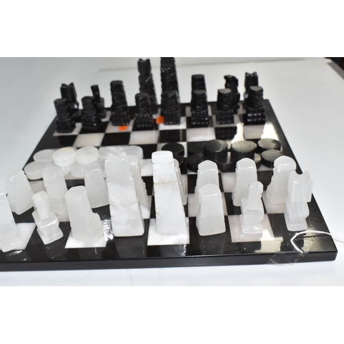 503 - A BLACK AND WHITE ONYX 'ABSTRACT AZTEC' CHESS SET with thirty-two chess pieces on a matching board, ... 