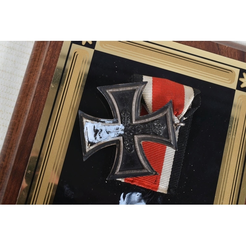 273 - A WWI GERMAN IRON CROSS AND TWO BRASS SHELLS, the Iron Cross has a magnetic centre and is attached t... 