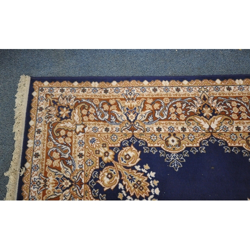 1236 - A BLUE GROUND RECTANGULAR WOOLLEN RUG, with a central medallion, repeating foliate patterns, surroun... 