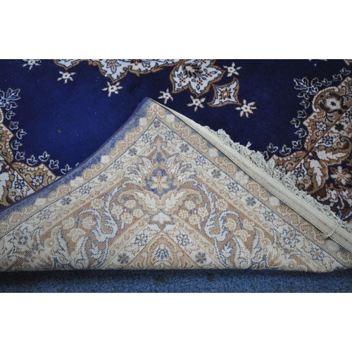 1236 - A BLUE GROUND RECTANGULAR WOOLLEN RUG, with a central medallion, repeating foliate patterns, surroun... 