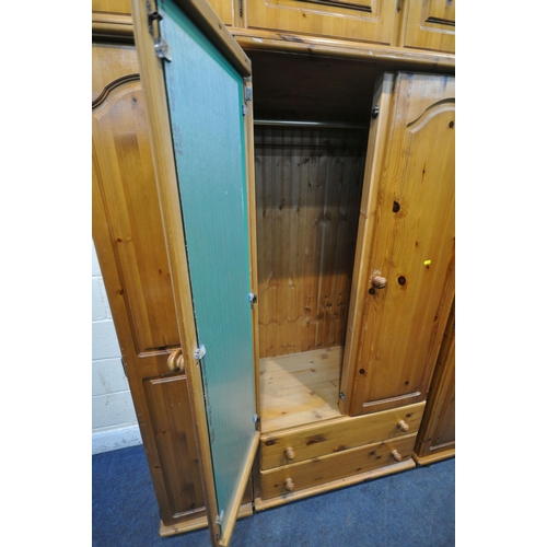 1250 - A MODERN PINE TRIPLE DOOR WARDROBE, with a three door section to the top, a central mirrored door, a... 