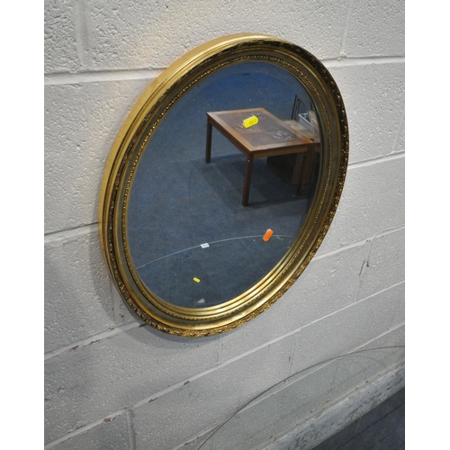 1272 - AN OVAL GLASS TOP COFFEE TABLE, the glass held by a lady, width 120cm x depth 66cm x height 44cm, an... 