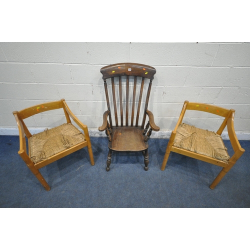 1335 - A 20TH CENTURY OAK ARMCHAIR, with swept armrests, raised on turned legs, united by stretchers, along... 