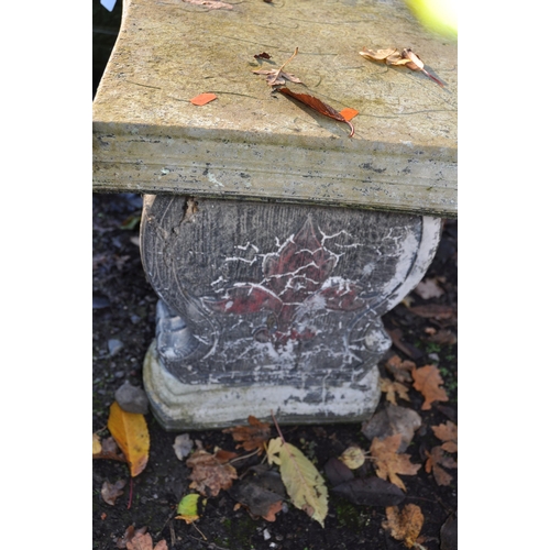 1021 - A WEATHERED COMPOSITE CURVED GARDEN BENCH, with painted bases adorned with Fleur de lis, and similar... 