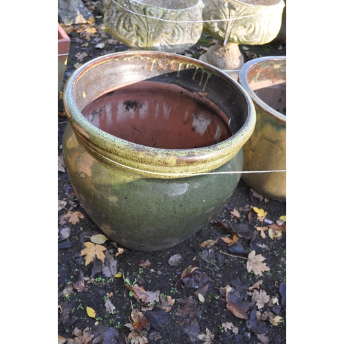 1024 - A SELECTION OF GREEN GLAZED PLANT POTS, including a set of three 46cm in diameter with an overlappin... 