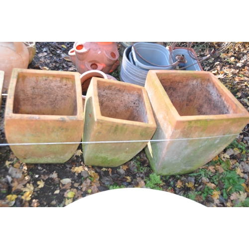 1027 - A COLLECTION OF TERRACOTTA COLOURED LARGE PLANT POTS including three square tapering baluster pots o... 