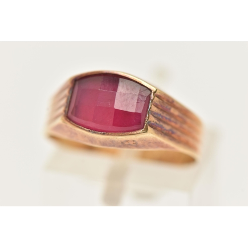 18 - A YELLOW METAL FANCY CUT RUBY RING, ruby collet set to the textured shoulders and polished band, rub... 